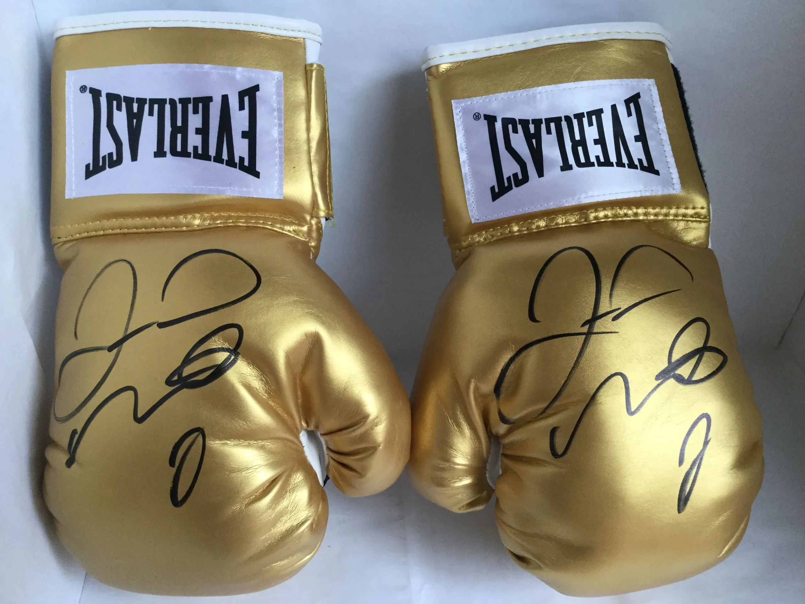 a pair of gold boxing gloves with black text